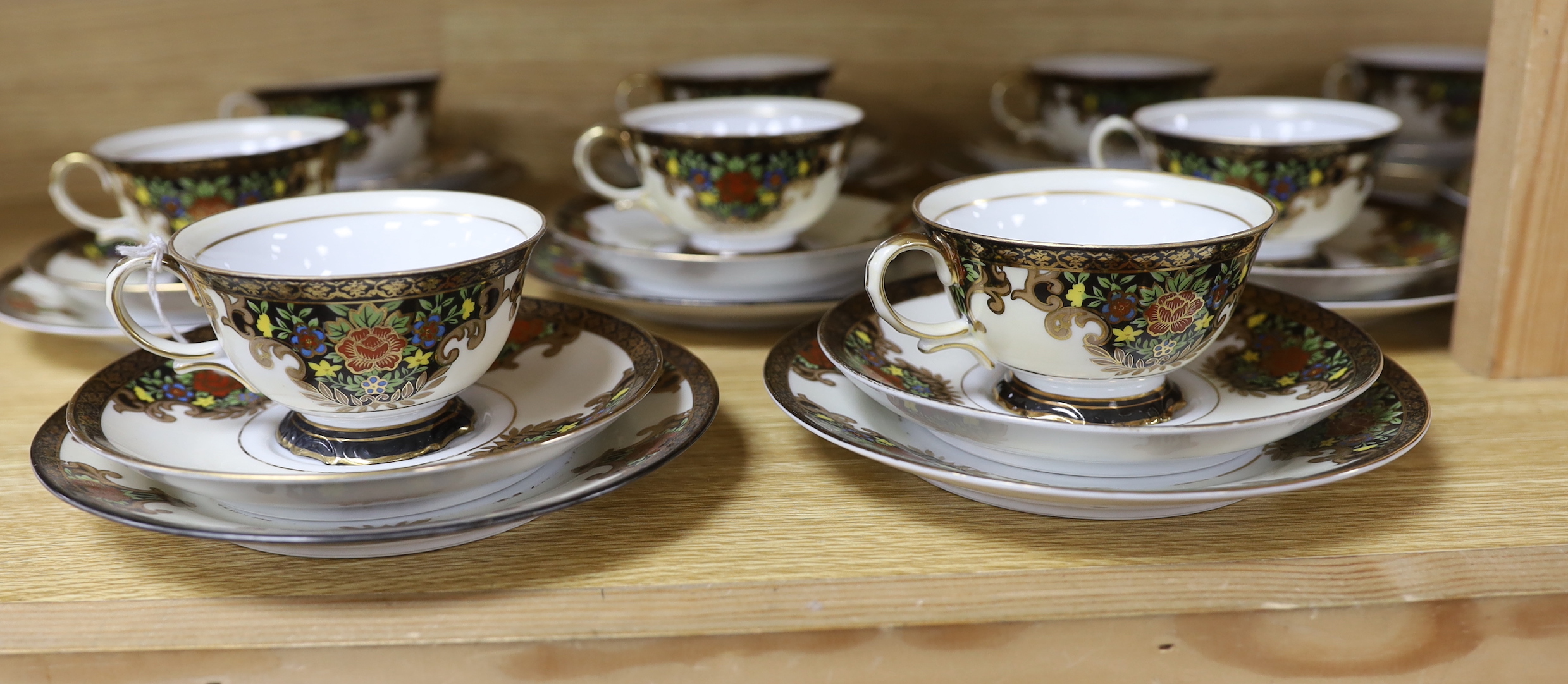 A Japanese Noritake floral and gilt tea set, comprising a sugar bowl, a milk jug, nine cups, plus saucers and tea plates